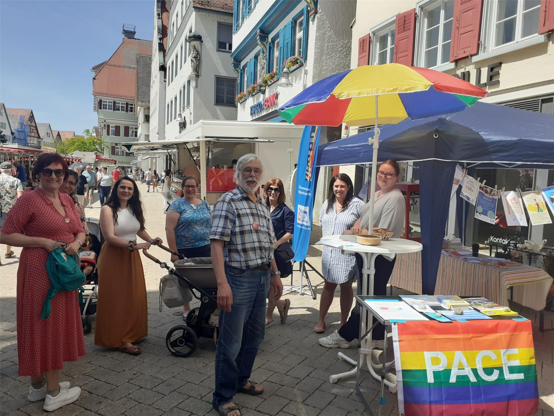 Marktstand mit interessierten Menschen über das Thema Migration sich zu unterhalten